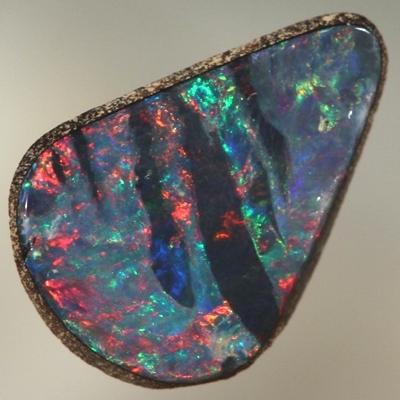 SOLID BOULDER OPAL Bright red and green surround black opal bands 